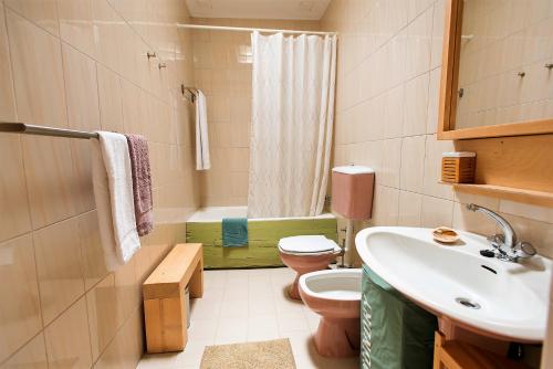 een badkamer met een toilet, een wastafel en een bad bij Casa do Remo Praia da Aguda in Arcozelo
