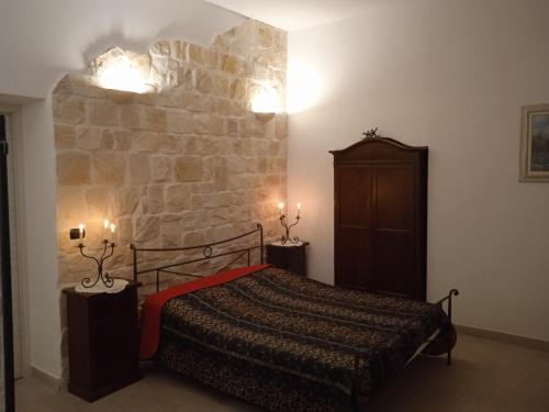 ein Schlafzimmer mit einem Bett und einer Steinmauer in der Unterkunft Villa don peppe in Selva di Fasano