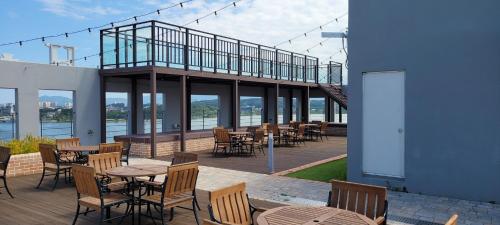 un patio con mesas y sillas en un edificio en Gangneung hi ocean gyeongpo a203 en Gangneung