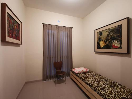 a bedroom with a bed and a chair in it at Mawartiga Homestay in Demangan