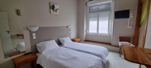 a bedroom with a bed and a desk and a window at Résidence SoAnSa du Gérardmer - Col de la Schlucht in Soultzeren