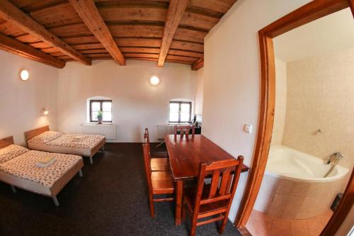 a room with a table and a bed and a bath tub at Apartmány Na Rynku Chvalšiny 18 in Český Krumlov