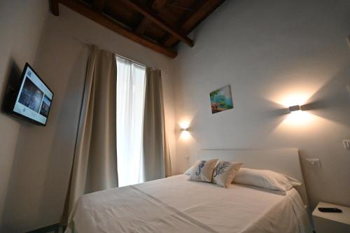 Un dormitorio con una cama blanca y una ventana. en La Memolina B&B, en Salerno