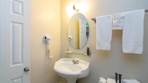 a bathroom with a sink and a mirror and towels at Americas Best Value Inn Rancho Palos Verdes in Rancho Palos Verdes