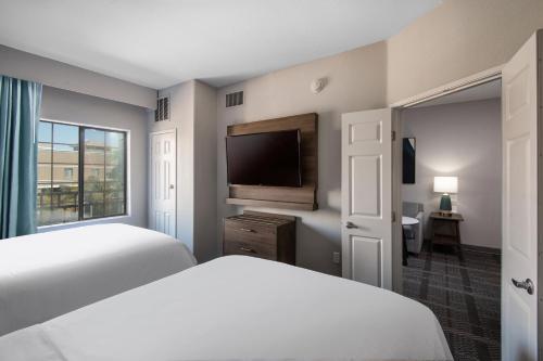 a bedroom with a bed and a flat screen tv at Staybridge Suites Phoenix Glendale Sports Dist by IHG in Glendale