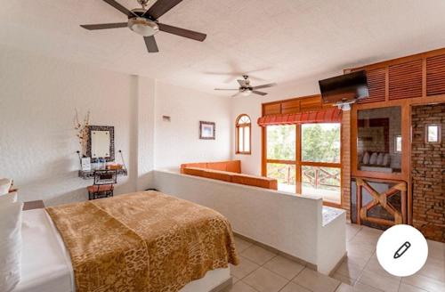 a bedroom with a bed and a living room at HOTEL VILLAS XAIBA in Puerto Escondido