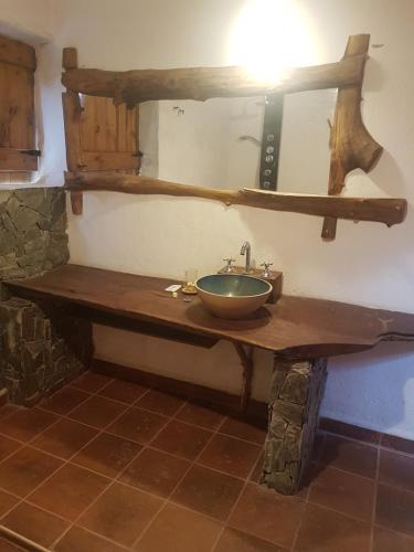 y baño con lavabo de madera y espejo. en Posada Villa Aurorita in 