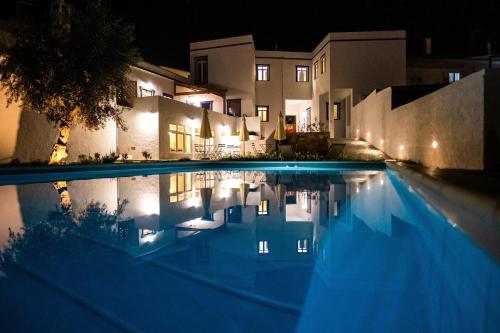 a swimming pool in front of a house at night at A Casa da Cerca in Almodôvar