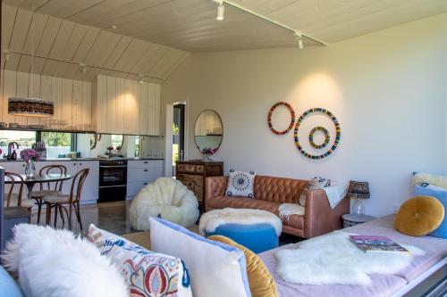 a living room with a couch and a kitchen at The Cottages at Lake Hayes in Queenstown