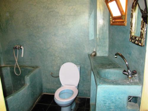 a bathroom with a toilet and a sink and a tub at Auberge Cavaliers in Aït Baha