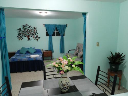 ein Wohnzimmer mit einem Tisch und einer Blumenvase in der Unterkunft DEPARTAMENTO CERCANO AL AEROPUERTO T2, A 2 CALLES in Mexiko-Stadt