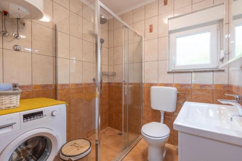 a bathroom with a washing machine and a toilet at Villa Strikina kuca in Slivno