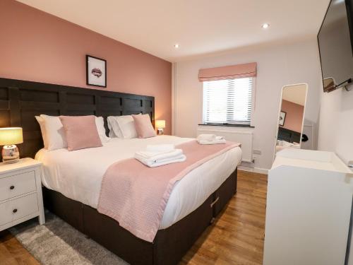 um quarto com uma cama grande e um espelho em The Coach House, Bank Top Farm em Ashbourne