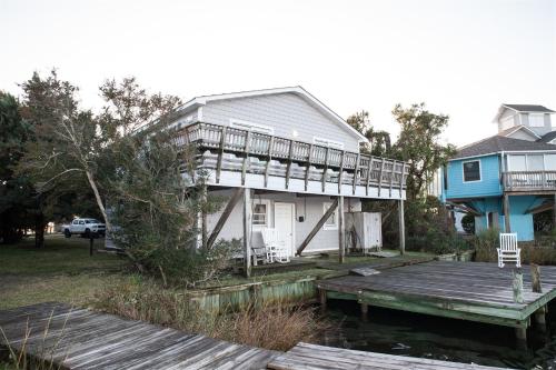 a house with a deck and a wooden dock at 57218 Island Club Lane Home in Hatteras