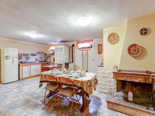 a kitchen with a table and a fireplace at Belvilla by OYO CASA MELIS in Carbonia