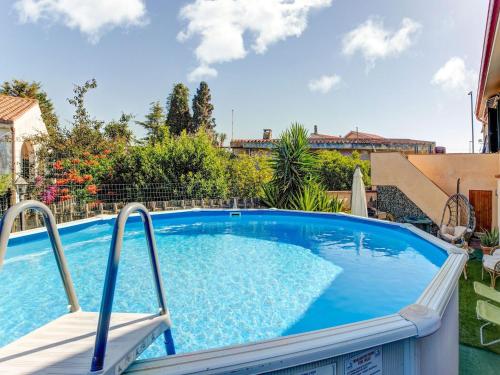 uma piscina com uma cadeira num quintal em Belvilla by OYO CASA MELIS em Carbonia