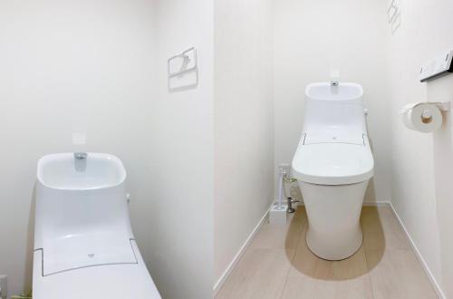 a white bathroom with a toilet and a sink at japan house shinkoiwa in Tokyo