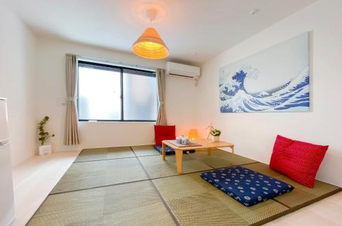 a living room with a table and red chairs at japan house shinkoiwa in Tokyo