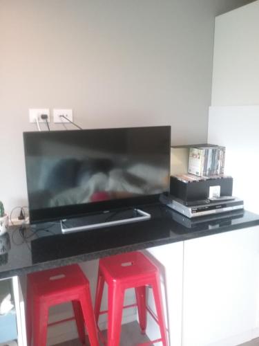 a black table with two red stools and a television at Best view on Westview in Hanmer Springs