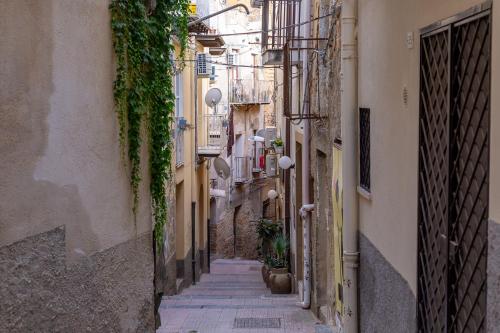 an alley in an old town with stairs and plants at BnB Sant'Alfonso in Agrigento