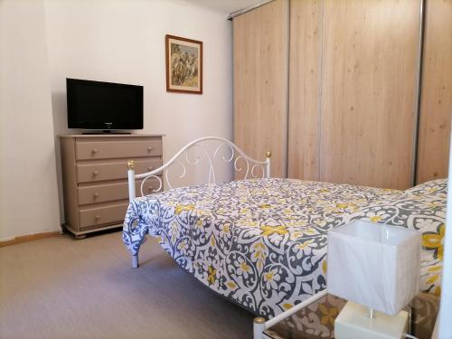 een slaapkamer met een bed en een tv op een dressoir bij MAISON CLIMATISEE ,2 CHAMBRES, PARKING compris in La Ciotat