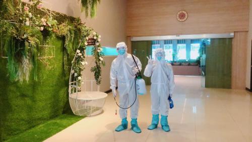 two people in protective gear standing in a room with at Eastpana Hotel - SHA Extra Plus in Si Racha