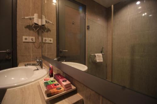 a bathroom with a sink and a mirror at Hotel Dafam Semarang in Semarang