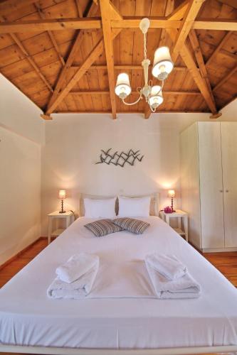 a bedroom with a large white bed with wooden ceilings at Katerina in Panormos Skopelos