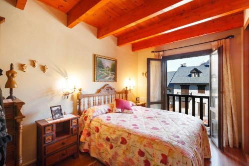 ein Schlafzimmer mit einem Bett und einem Balkon in der Unterkunft Torres de Vallibierna in Benasque