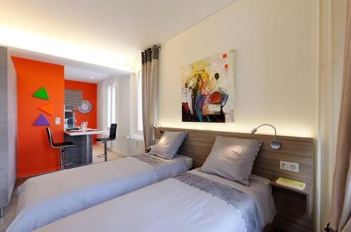 ストラスブールにあるアパルトマン コム シェ ソワのオレンジ色の壁のベッドルーム1室(ベッド2台付)