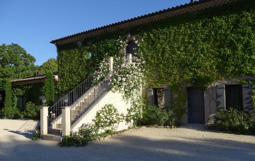a building with stairs and ivy on it at Maison du Lac in Les Angles Gard