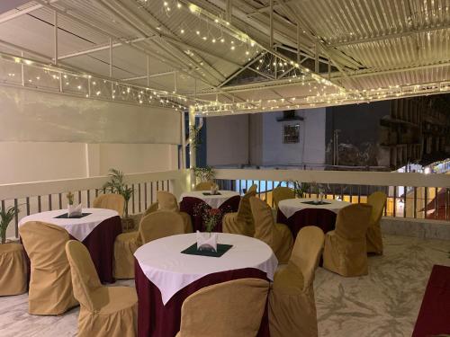 a dining room with tables and chairs and lights at Hotel Saluja in Siliguri