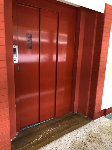 a red elevator door in a red building at Hotel Saluja in Siliguri