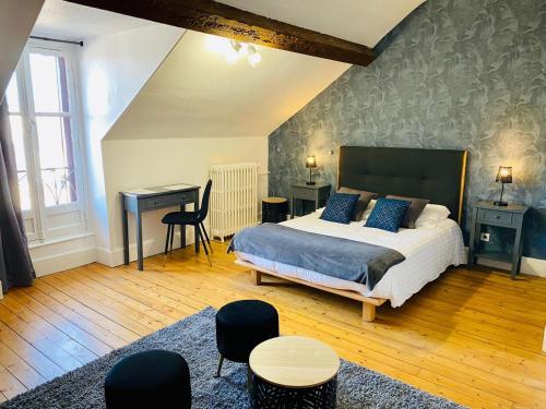 a bedroom with a bed and a desk and a desk at Logis Hotel La Tourelle du Beffroi in Bourbon-Lancy