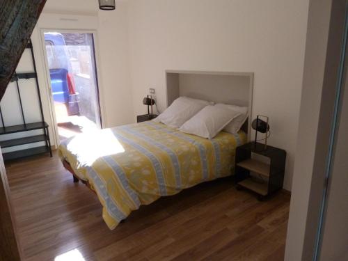 - une chambre avec un lit doté d'une couverture jaune et bleue dans l'établissement Chez Marcel Gite PMR, à La Marne