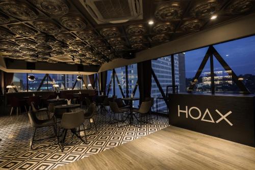 a restaurant with a bar with a view of the city at Awann Sewu Boutique Hotel and Suite Semarang in Semarang