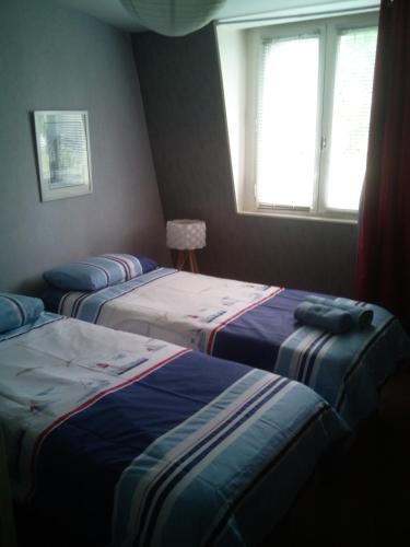 une chambre avec trois lits et une fenêtre dans l'établissement Faré Flammek, à Dinard