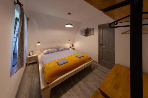 a bedroom with a large bed with a yellow blanket at Timber valley in Plitvička Jezera