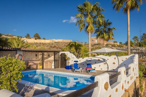 ein Pool in einem Resort mit Palmen in der Unterkunft CASANTILVIA heated pool paradise in Adeje