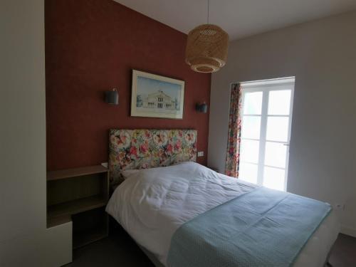 een slaapkamer met een bed en een raam bij Appartement Escapade Vitaminée - Maison d'Aligre in Marans