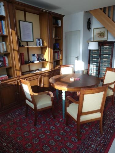 a dining room with a wooden table and chairs at VILLA CHAMPAGNE in Colombey-les-deux-Églises
