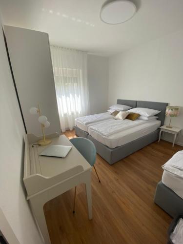 a bedroom with two beds and a table and a desk at Apartma pri nani in Kobarid