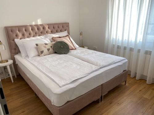 Una cama con sábanas blancas y almohadas en un dormitorio en Apartma pri nani, en Kobarid