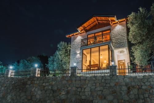 a house with a stone wall at night at Rustic Villas Barlovic in Ulcinj