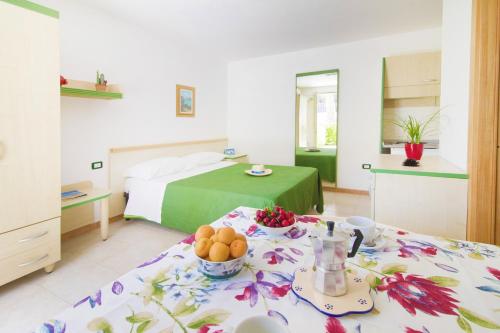 a bedroom with a bed and a table with fruit on it at Vaia Residence in Torre dell'Orso