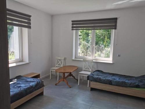 a room with two beds and a table and windows at Reda apartments in Lublin
