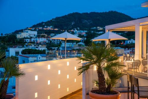 a balcony with tables and umbrellas on a building at Hotel Villa Durrueli Resort & Spa in Ischia