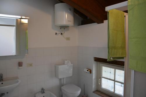 a bathroom with a toilet and a sink and a window at Apartment Monika in Udine