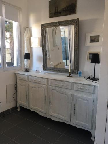 un miroir au-dessus d'une commode dans une pièce dans l'établissement Baie Sud Cayeux sur Mer ciel, à Cayeux-sur-Mer