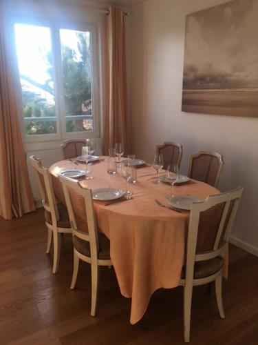 une table en bois avec des chaises et une table avec des verres à vin dans l'établissement Baie Sud Cayeux sur Mer ciel, à Cayeux-sur-Mer
